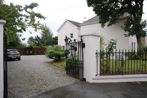 une maison blanche avec une porte noire et une allée. dans l'établissement Glenart House, à Tramore