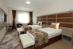 a hotel room with two beds and a desk at Seckin Hotel in Sakarya