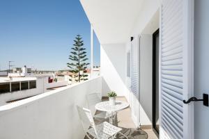 a white balcony with a table and chairs at Destino Sitges in Sitges