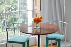 a table with a bowl of oranges and two chairs at ALTIDO Cosy 1-bed flat in Angel, close to tube in London