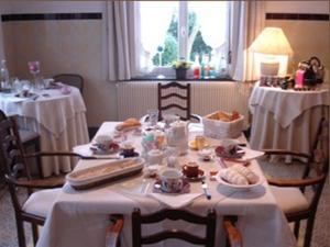 un comedor con una mesa con comida. en Manoir de la Peylouse, en Saint-Venant