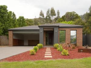 a home with a brick house with a driveway at Montebello in Bright