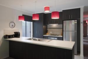 a kitchen with a sink and a refrigerator and pendant lights at Montebello in Bright
