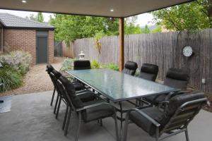 a patio with a glass table and chairs at Montebello in Bright