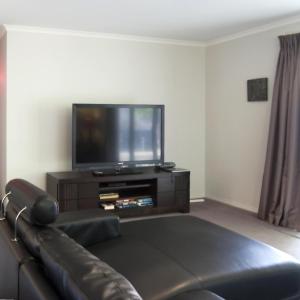 a living room with a couch and a flat screen tv at Montebello in Bright