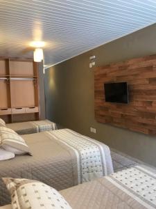 Uma TV ou centro de entretenimento em Amoreiras Hotel Pousada