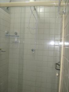 ein Bad mit einer Dusche und einer Glastür in der Unterkunft Flat em Pitangueiras - Guarujá in Guarujá