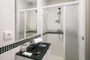 a white bathroom with a sink and a shower at Camarinha Oporto Apartments in Porto +32 photos