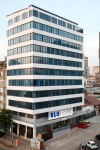 un gran edificio blanco con un cartel azul en el cielo en Blu Sky Hotel, en Maputo
