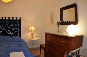 una camera con letto, cassettiera e specchio di Casa Frida a Palermo