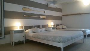 ロレートにあるB&B A Portata di Mareのベッドルーム1室(ベッド2台、ランプ2つ付)