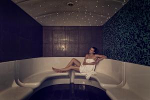 
a woman sitting on a bath tub in a bath room at Inntel Hotels Art Eindhoven in Eindhoven
