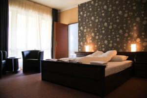 a bedroom with a large bed and a window at Hotel Korona in Harkány +20 photos