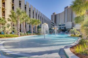 a fountain in front of a building with palm trees at Emerald Beach Resort in Panama City Beach