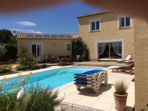 a villa with a swimming pool in front of a house at Le Claouraous calme in Canet