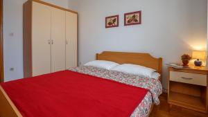 a bedroom with a bed with a red blanket at Apartment Josephine 2 in Malinska