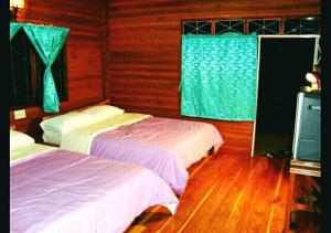 Un pat sau paturi într-o cameră la Rayong Phurua Resort