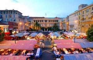 un marché en plein air dans une ville avec des tables et des chaises dans l'établissement BARILLERIE - Loft Moderne, Face Mer, Vieux-Nice., à Nice