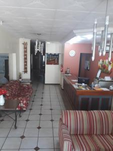 a living room with two couches and a kitchen at Turis Hotel in Santo Ângelo