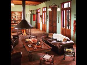 a living room with a leather couch and a table at La Negrita Casa de Campo in Azcuénaga