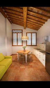 une cuisine avec une table et un canapé jaune dans l'établissement Agriturismo Casanova di Nardini, à Scandicci