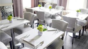 a dining room with white tables and chairs at 33 Main in Lenox