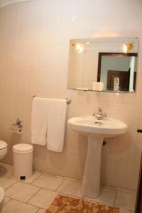 uma casa de banho com um lavatório, um WC e um espelho. em Restaurante e Residencial O Resineiro em Vidago