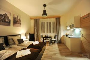 a bedroom with two beds and a kitchen and a table at Apartmány Kukučín in Košice