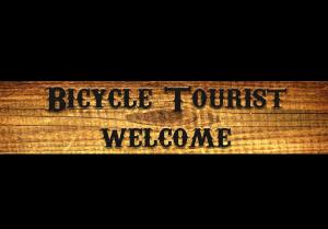 a wooden sign with the words bicycle tourist welcome at Hillankukka in Äkäslompolo