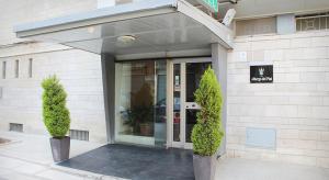 un ingresso a un edificio con due alberi di fronte di Albergo dei Pini ad Andria