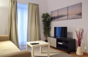 een woonkamer met een tv en een salontafel bij Family House in Lissabon