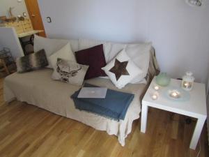 Cap del Tarter Apartament في التارتر: غرفة معيشة مع أريكة مع وسائد وطاولة