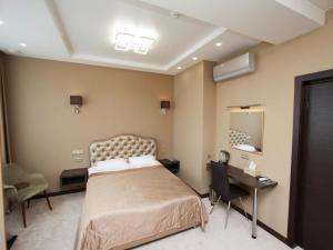 um quarto com uma cama, uma secretária e um espelho em Hotel Vladpoint em Vladivostok