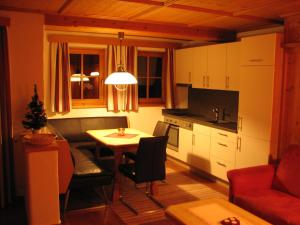 a kitchen with a table and a living room at Appartement Lotte Familie Grünberger in Brixen im Thale