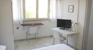 um quarto com uma secretária, um computador e 2 cadeiras em Albergo dei Pini em Andria