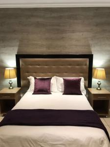 a bedroom with a large bed with purple pillows at TeBeacon Accommodation in East London