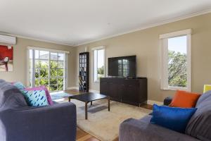 a living room with two couches and a tv at Ocean Breeze Retreat - with spa and space in Saint Andrews Beach