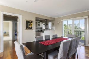 a dining room with a black table and chairs at Ocean Breeze Retreat - with spa and space in Saint Andrews Beach
