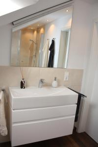 a bathroom with a white sink and a mirror at Ferienwohnung "Am Wald 1" in Boppard +8 photos
