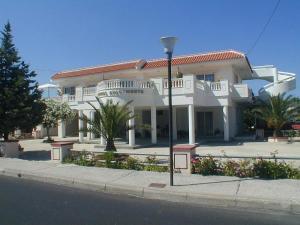 a large white house on the side of the street at COLONIAL FAMILY apartment #3 in Faliraki