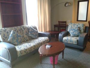 a living room with a couch and chairs and a table at FnF Suite @ Time Square in Kuala Lumpur