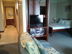 a hotel room with a couch and a television at FnF Suite @ Time Square in Kuala Lumpur