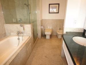 a bathroom with a tub and a toilet and a sink at FnF Suite @ Time Square in Kuala Lumpur