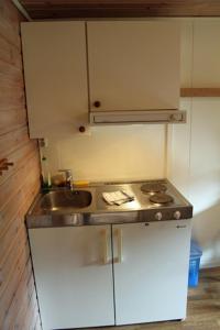 a small kitchen with a sink and a stove at Fosseland Gjestegård in Feda