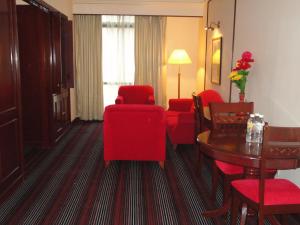 a hotel room with red furniture and a table and chairs at FnF Suite @ Time Square in Kuala Lumpur
