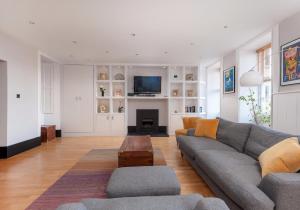 ein Wohnzimmer mit einem grauen Sofa und einem Kamin in der Unterkunft Parliament Sq (apt 3) Royal Mile in Edinburgh