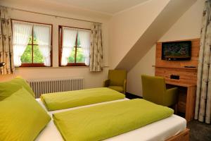 a bedroom with two beds and a desk and windows at Hotel Gasthaus Zum Hirschen in Simonswald