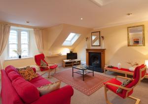 uma sala de estar com um sofá vermelho e uma lareira em Parliament Sq (apt 5) Royal mile em Edinburgo