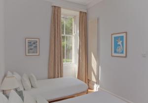 The Edinburgh Address - Classic Marchmont Charm في إدنبرة: غرفة نوم بيضاء بها سرير ونافذة