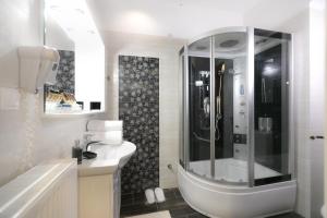 a white bathroom with a shower and a sink at Xenonas Epavli in Levidi